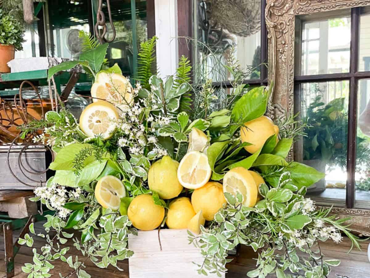Flower arrangements are made with greens and fresh lemons.
