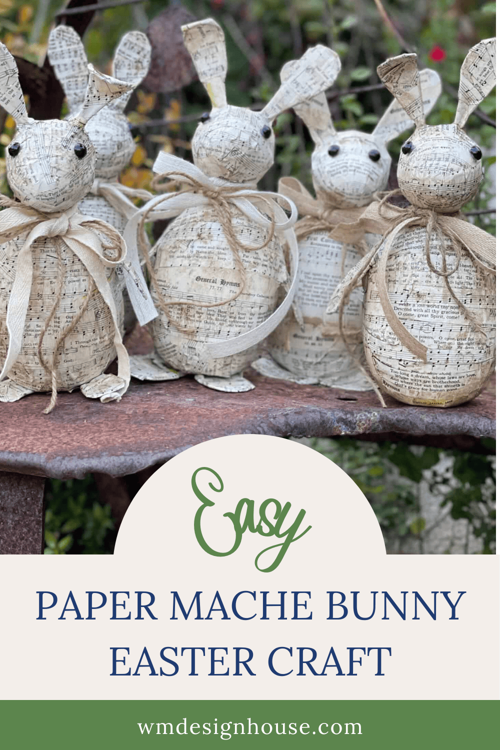 Four handmade Paper Mache Easter Bunny figures, decorated with vintage sheet music and ribbon bows, are displayed outdoors. Text reads: "Easy Paper Mache Bunny Easter Craft." Website: wmdesignhouse.com.