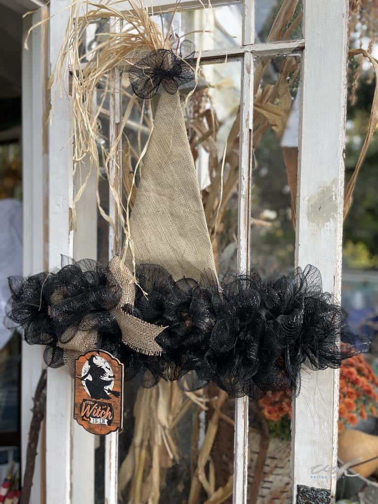 DIY Halloween Decor witch's hat wreath displayed on a rustic door