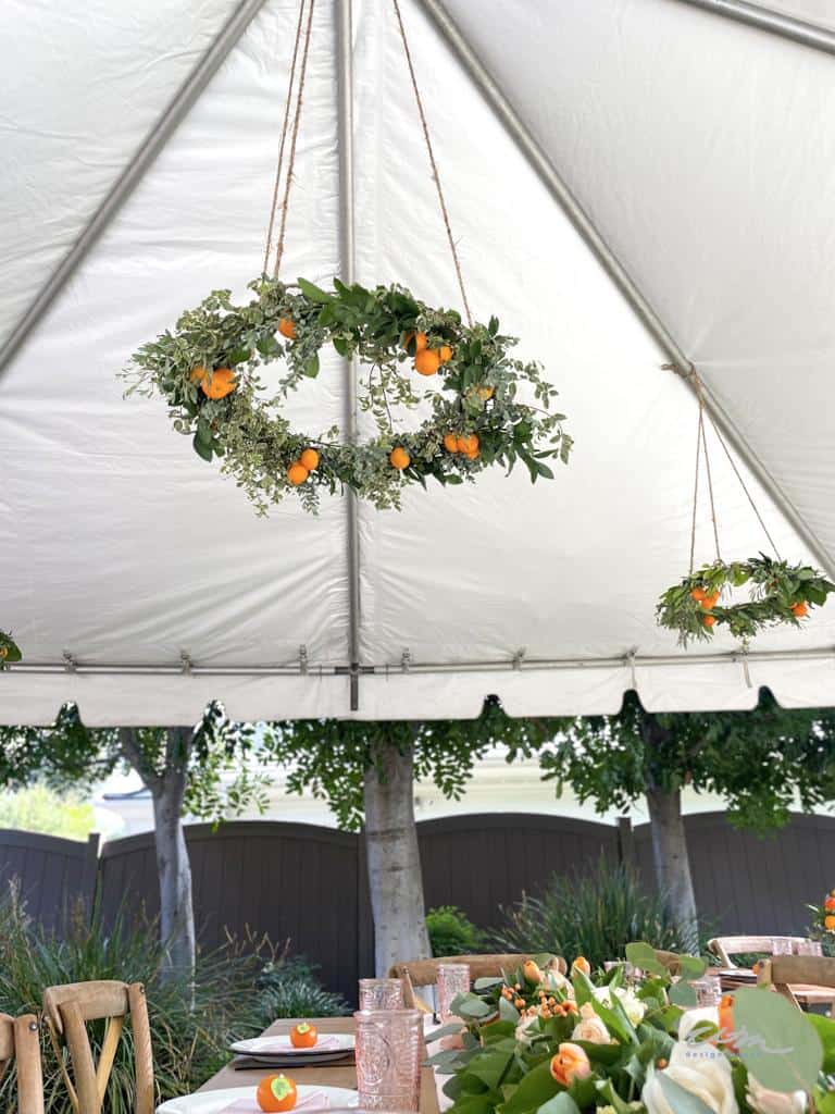wreaths hanging in a tent over tables 