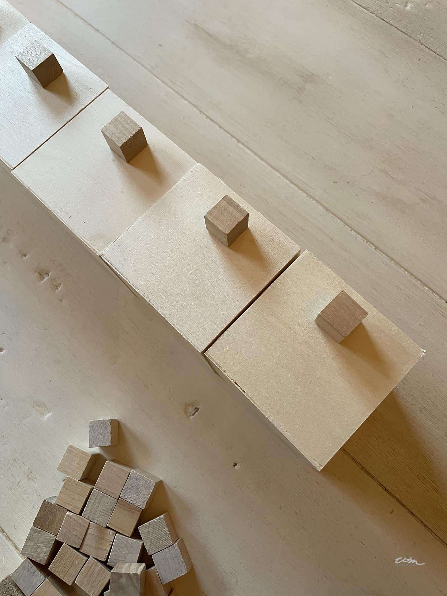 Gluing wood cube handles on boxes for a DIY Christmas advent calendar