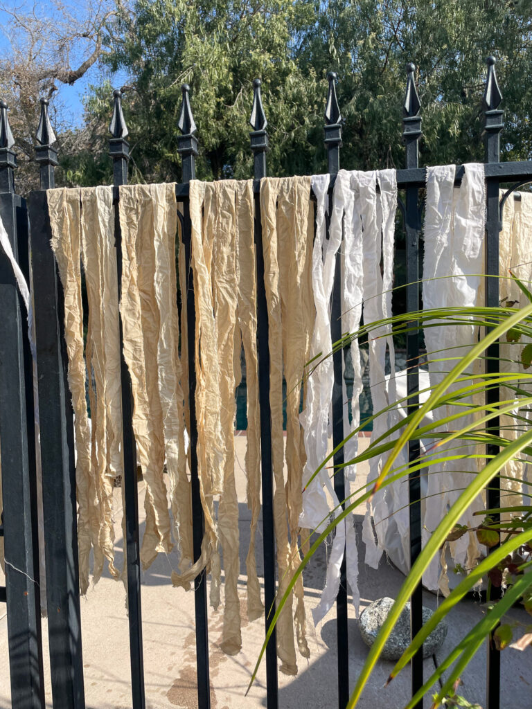 Drying tea-dyed fabric strips outside in the sun before making a DIY Rag Wreath. 