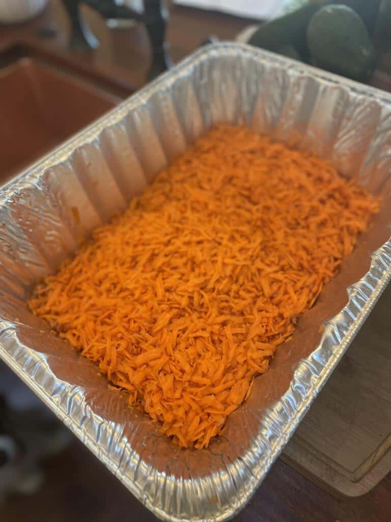 grate whole fresh carrots into a roasting pan, then boil water and pour over shredded carrots