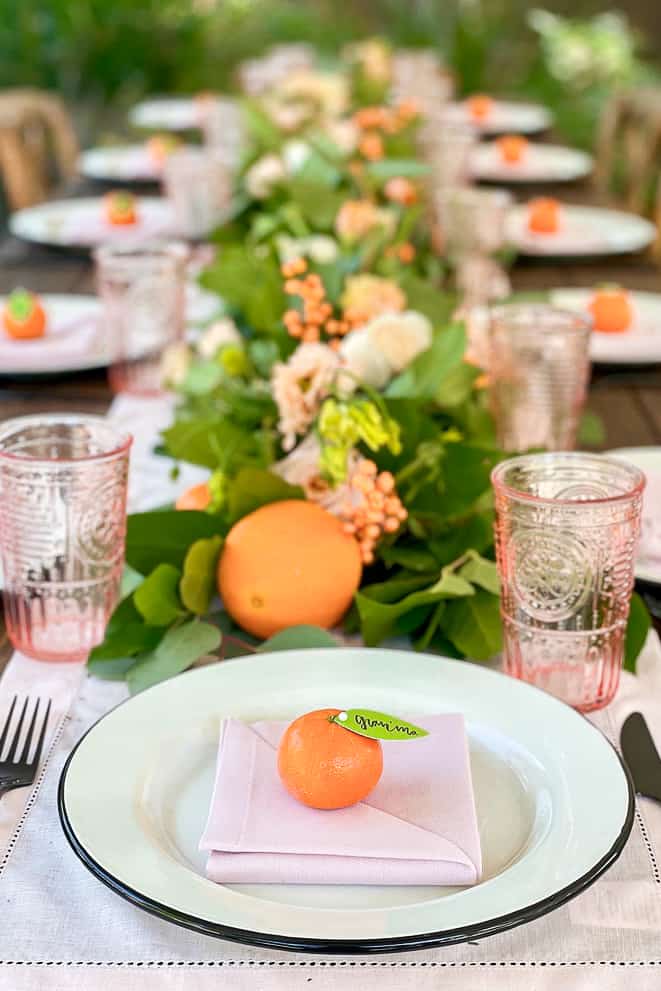 Tablescape in pink and orange with little cuties and pink glasses. 