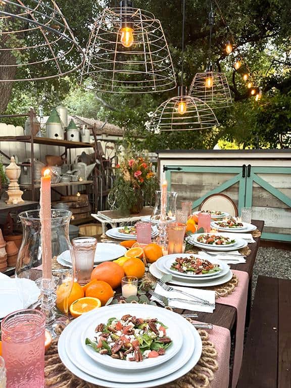 DIY pendant lights hanging above an outdoor table in the garden