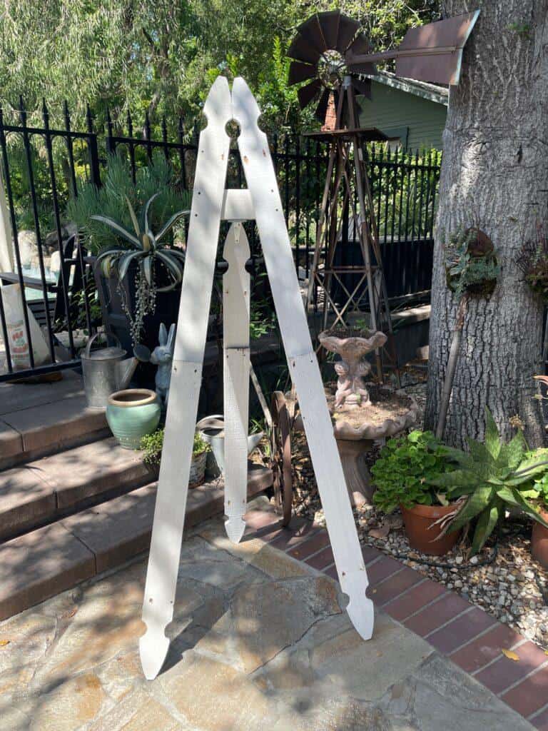 Upcycle a picket fence-How to Upcycle an Old Picket Fence into a Creative Easel- the three legs attached to each other and standing up. 