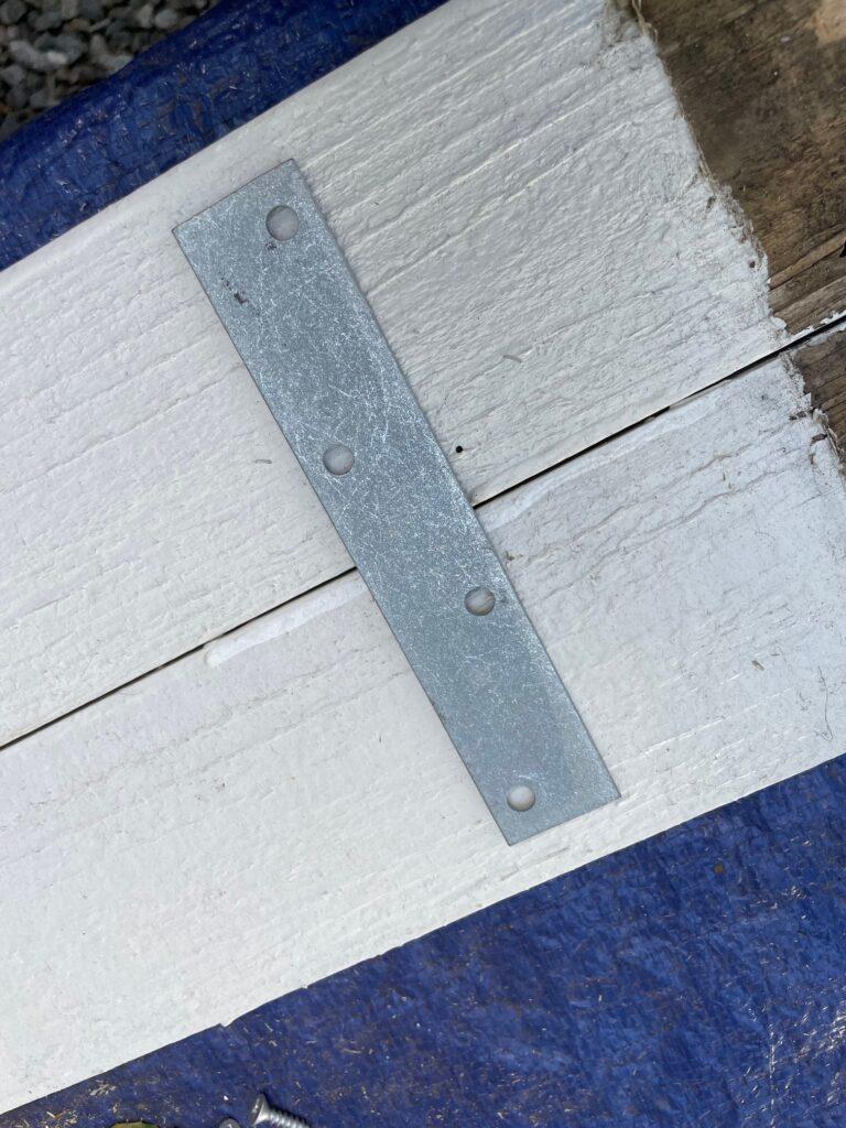 To create a shelf, we cut two of the pickets to 22" long, cut off the point and attached them together with these metal straps.