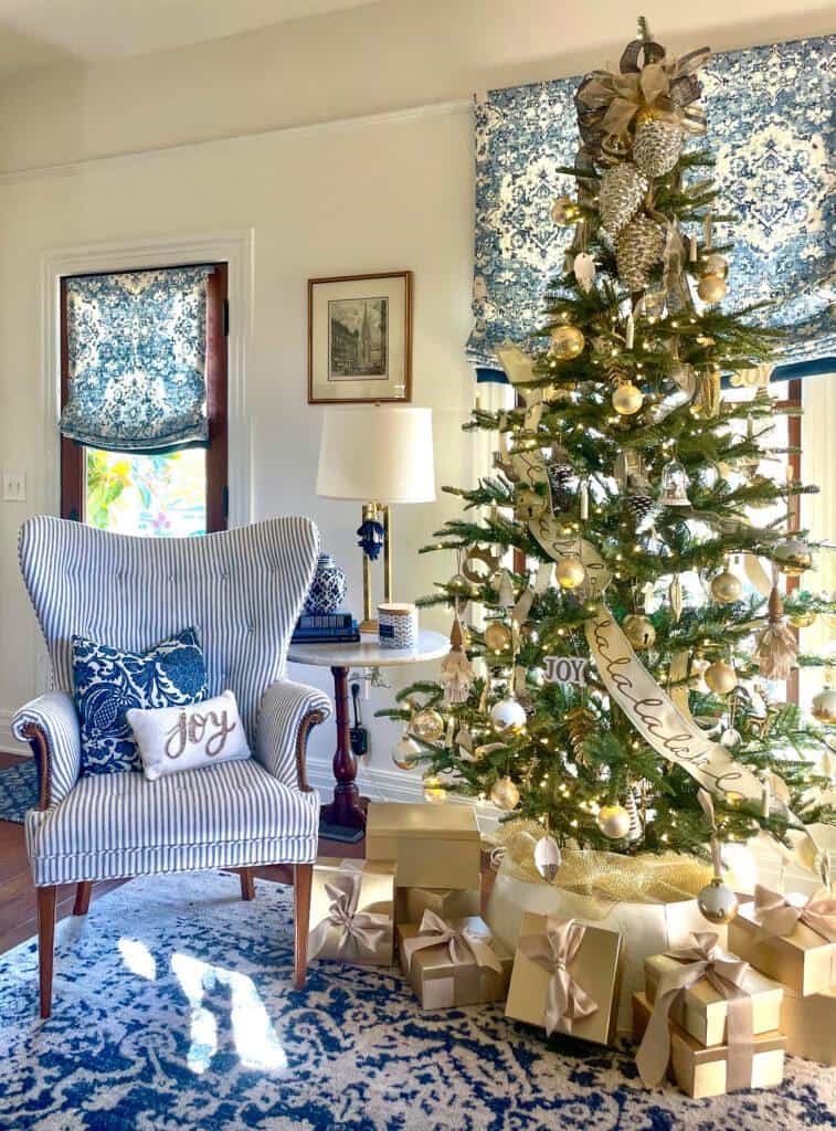 King of Christmas King Noble tree with gold and white decorations in a blue and white room 