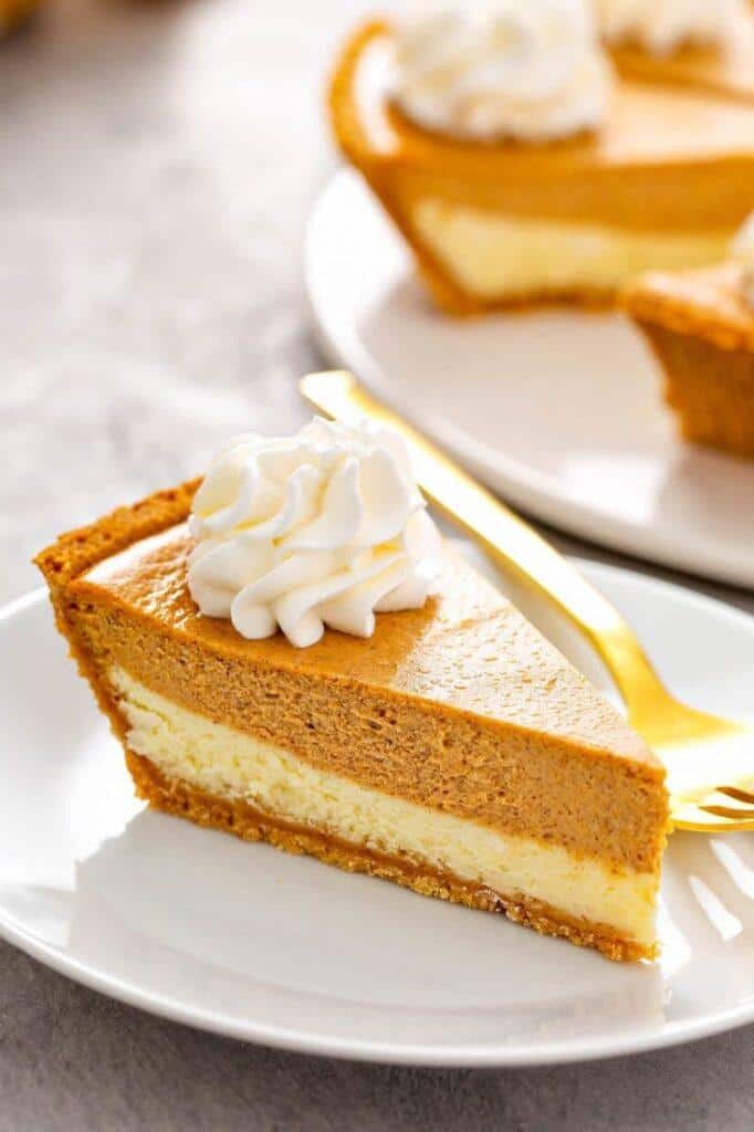 Slice of pumpkin pie cheesecake with whipped cream