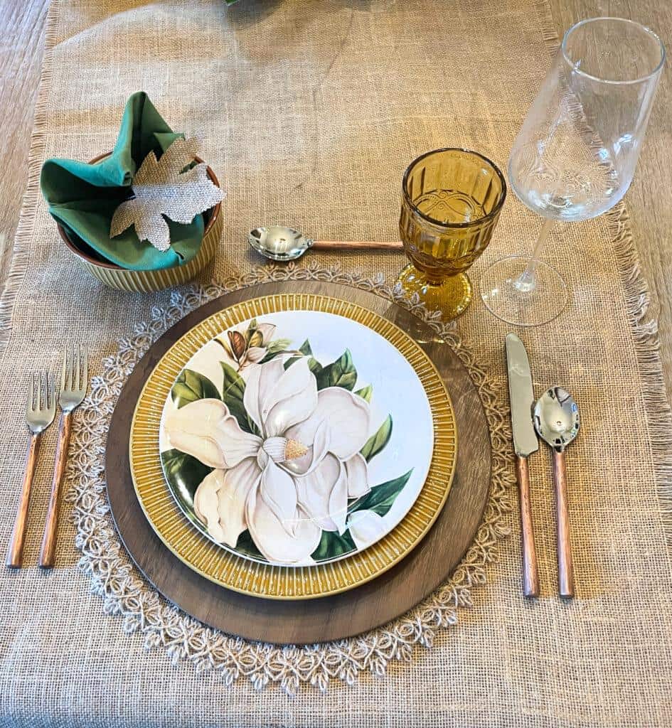 fall table setting with fall table runner, placements, charger, dinner plate, salad plate, bowl, napkin, silverware, and glasses