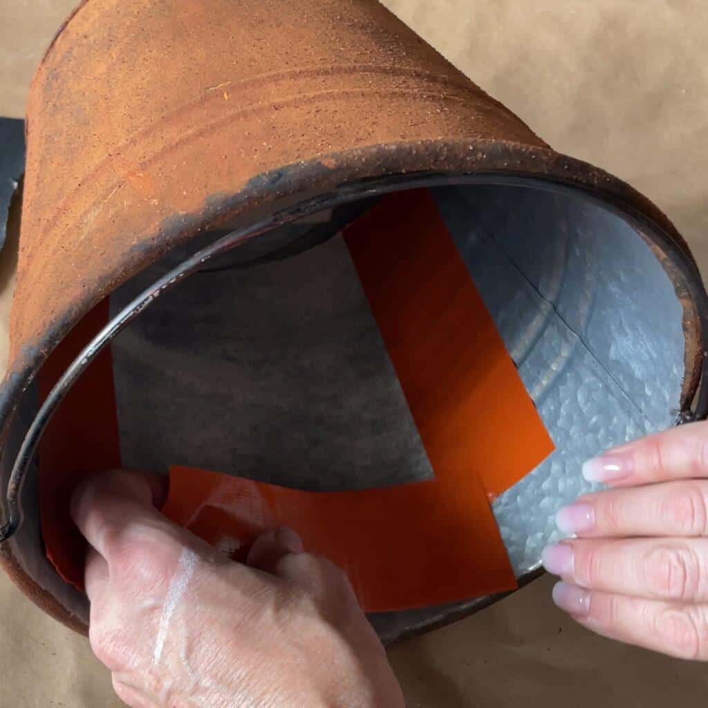 attaching fabric over the face of a pumkin bucket 