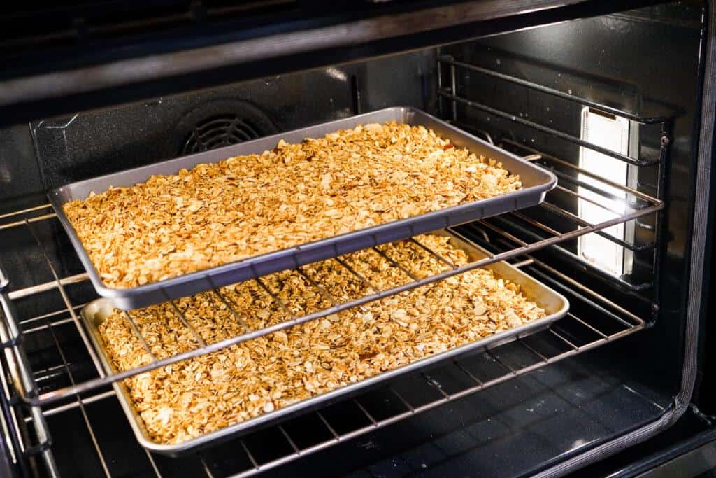 two trays of glulten free granola in the oven 