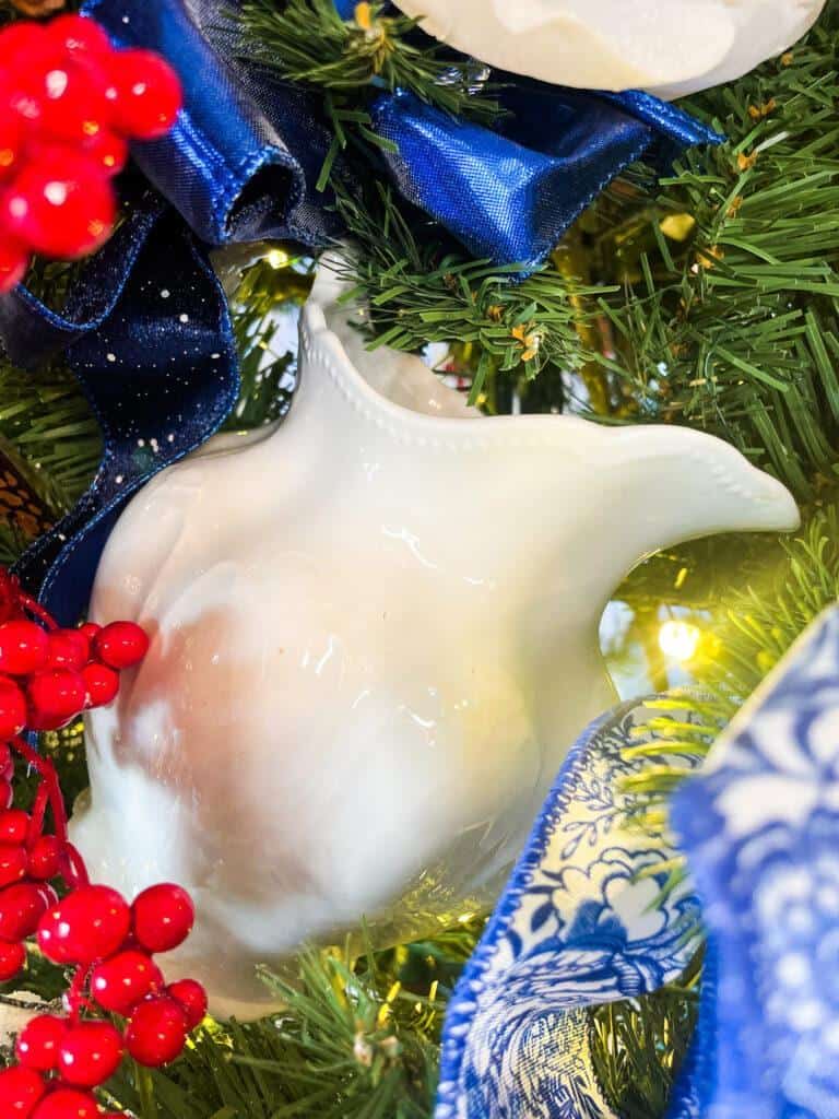 White ironstone pitcher hanging in a christmas tree 