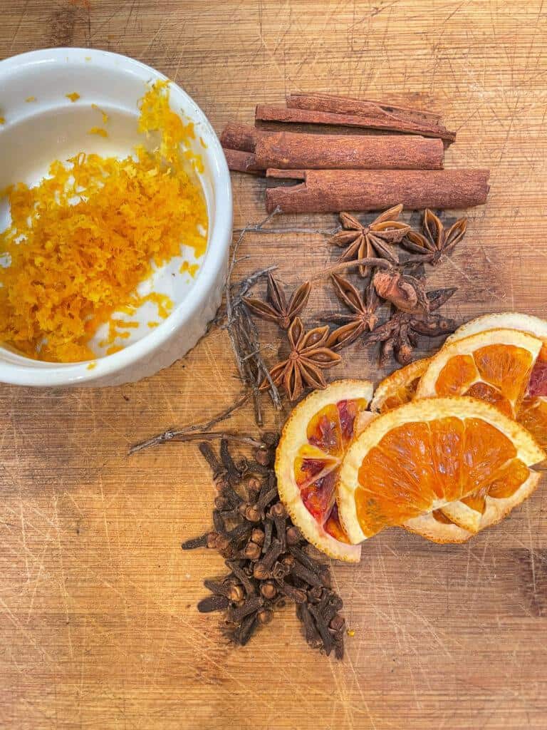 Dried orange slices, orange zest, cloves, cinnamon sticks, and anise star. 