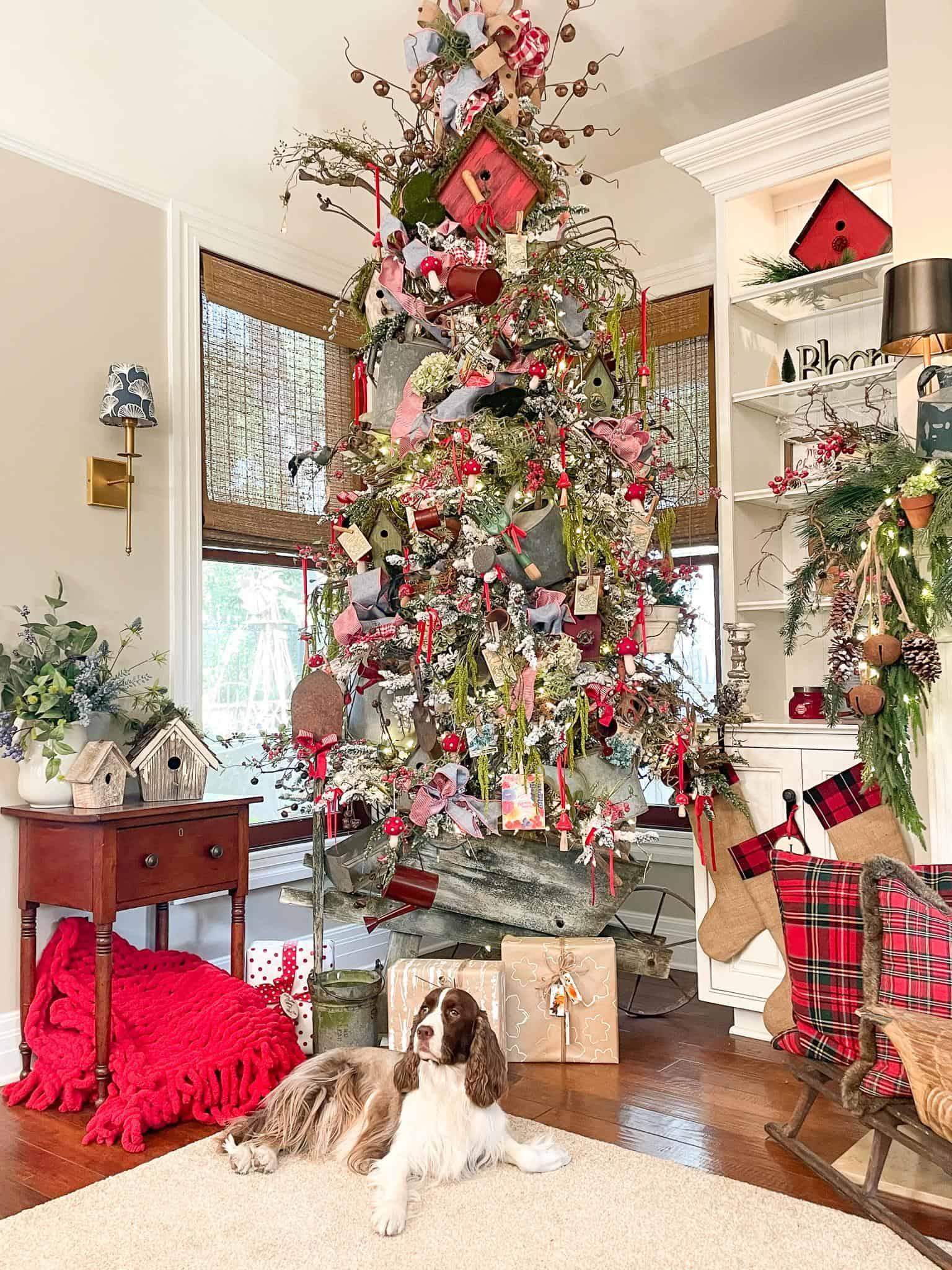 Classic Christmas in the Family room with a beuatiful christmas tree decorated with garden tools. birdhouses, shovels and standing in a wheelbarrel.