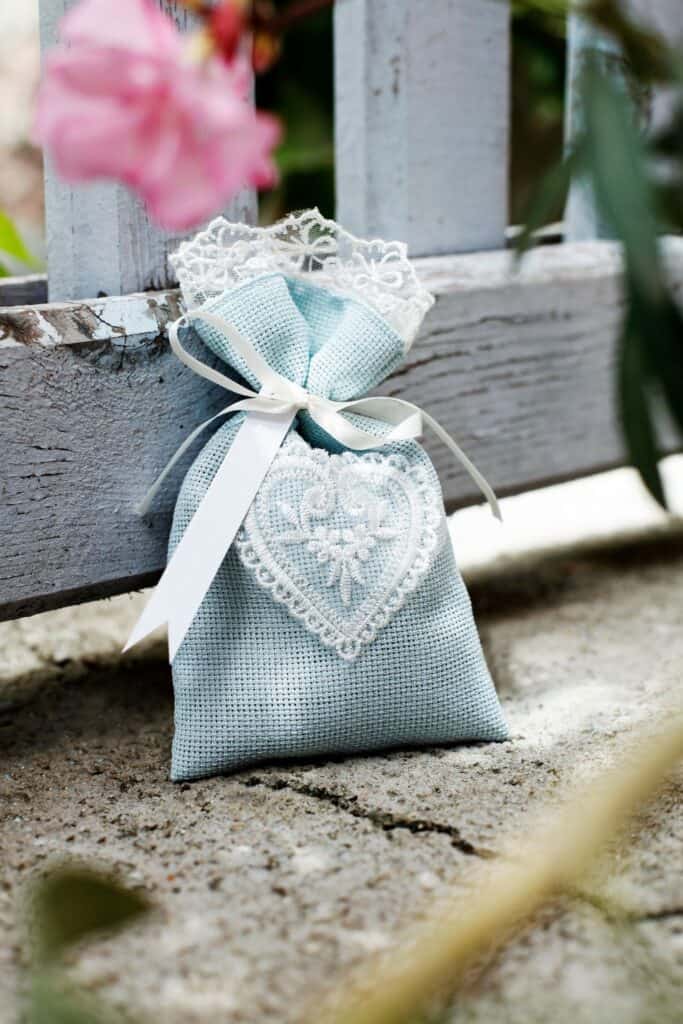 A small linen bag with white lace that holds wax sachets. 