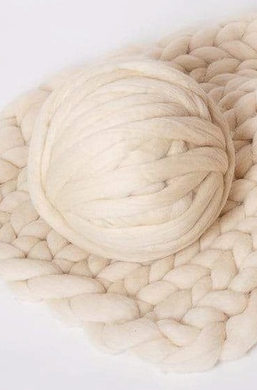 Ball of off-white wool yarn. 