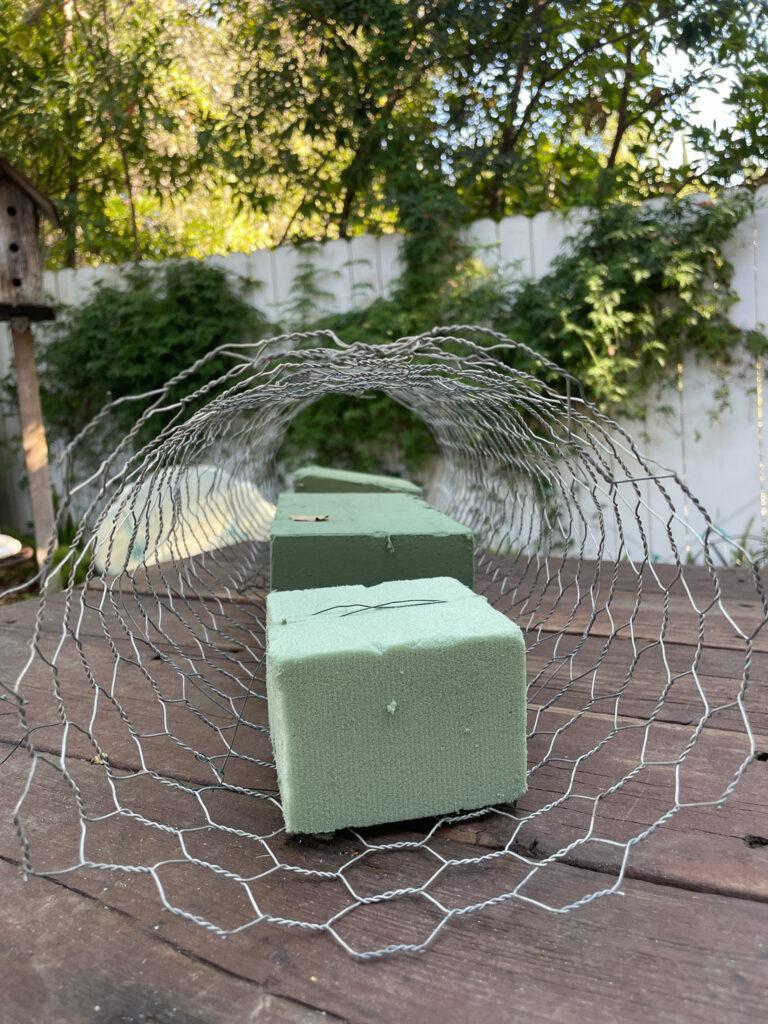 Chicken wire tube to create an outdoor chandelier with fresh greenry 