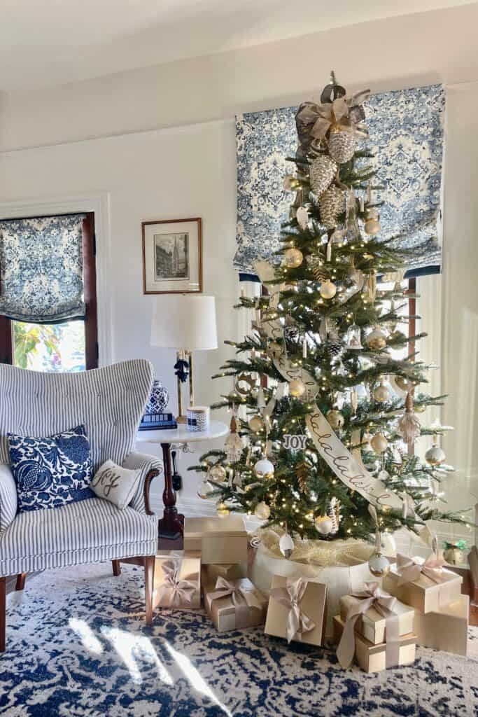Blue and white living room with a Christmas tree decorated in all gold and white 