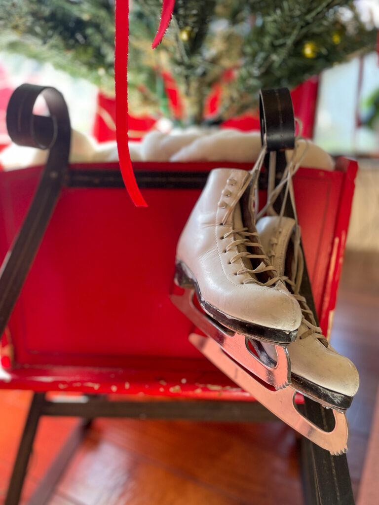 RED SLEIGH WITH WHITE SKATES HOLDING CHRISTMAS TREE
