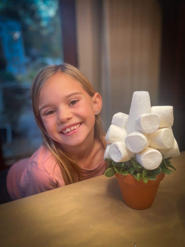 girl making DIY marshmallow Christmas trees