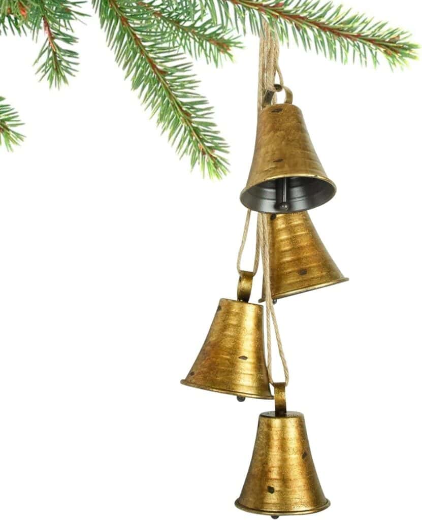 Set of four gold church bells hanging with fresh greens.