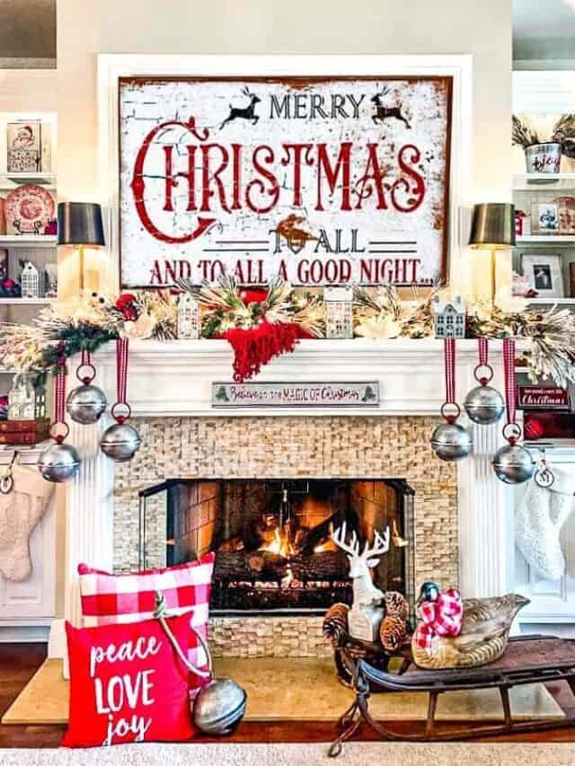 The fireplace is decorated for Christmas with bells hanging from the mantel.A Christmas sign hangs above with lots of red and white.