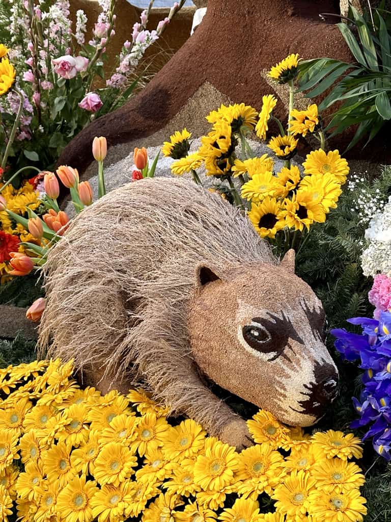 A Rose Parade float covered with flowers, seeds, greenery and more.