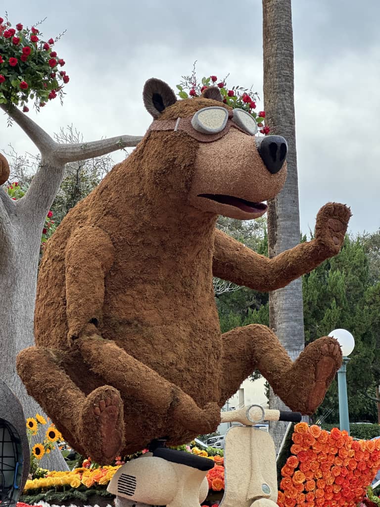 A Rose Parade float covered with flowers, seeds, greenery and more.