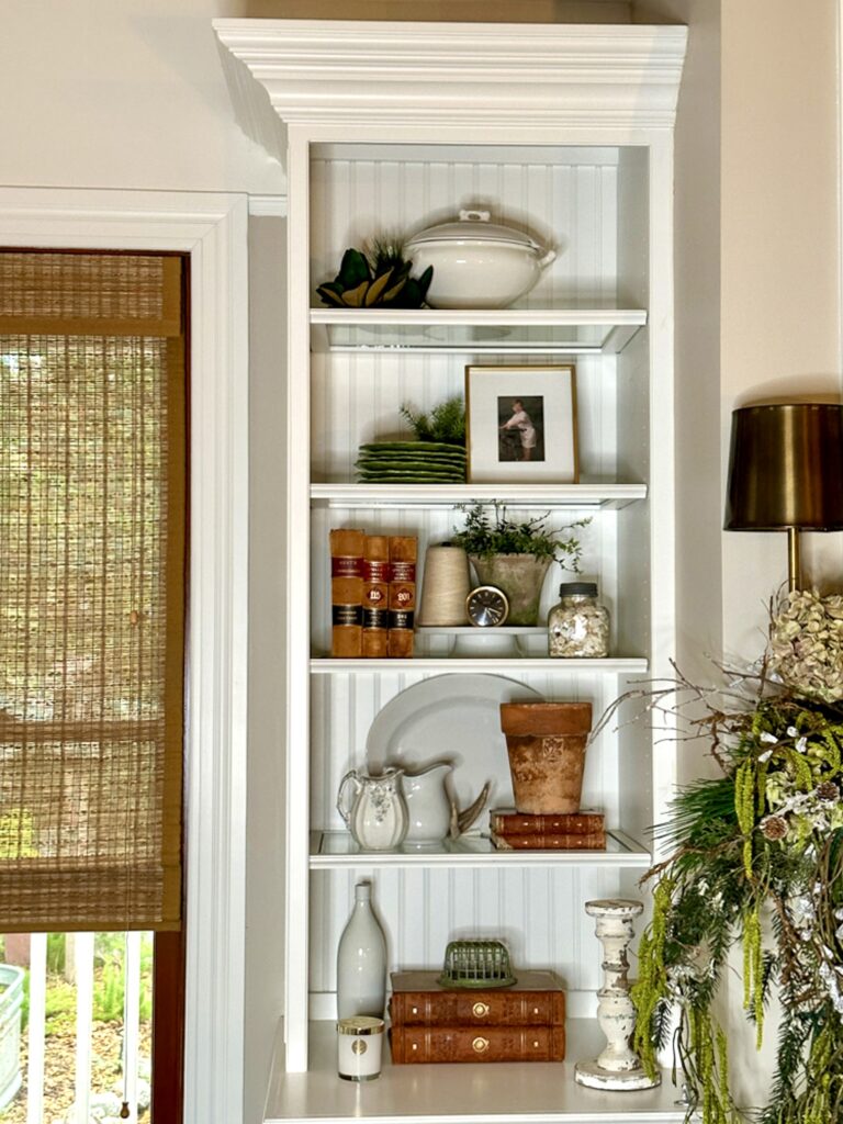Shelf styling with white ironstone, books and greenery.