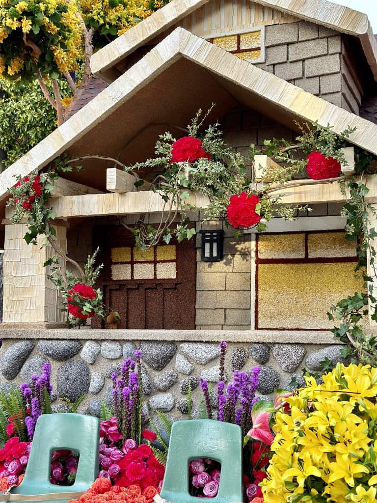 A Rose Parade float covered with flowers, seeds, greenery and more.