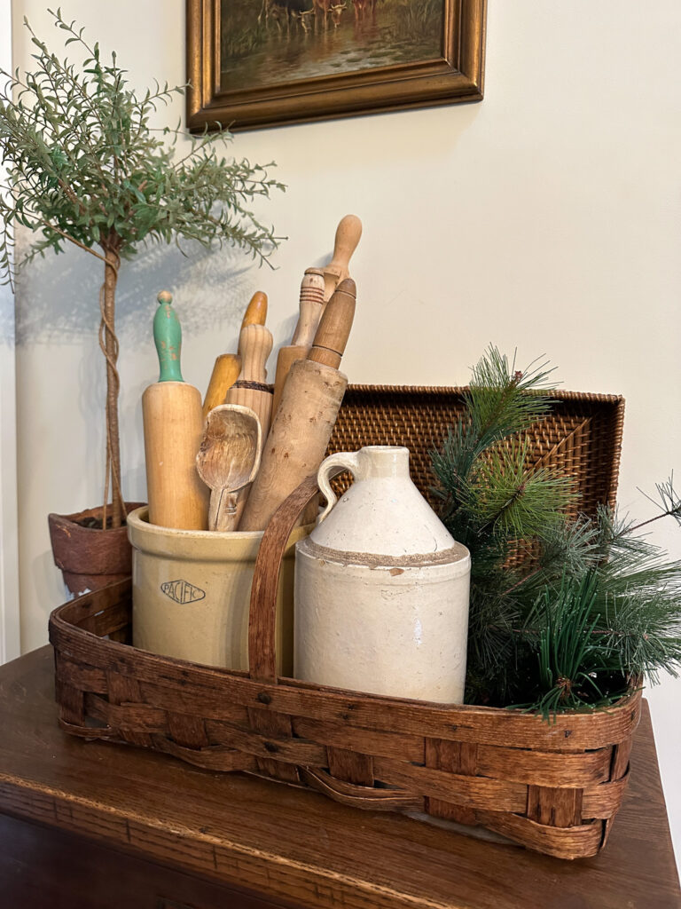 Basket with old crocks, rolling pins and winter greenery 