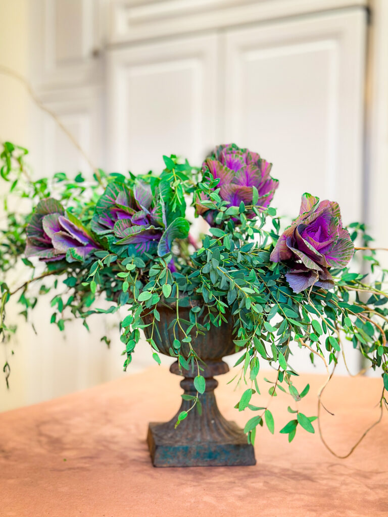 greenery and purple baby cabbage  in urn on kitchen counter-Winter floral arrangement