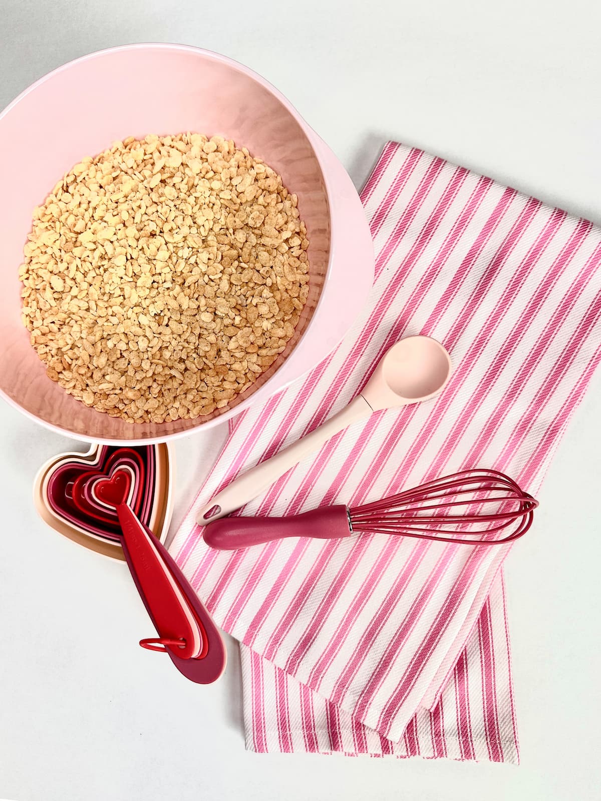 rice krispies in a bowl, tea towels, and measuring spoons 