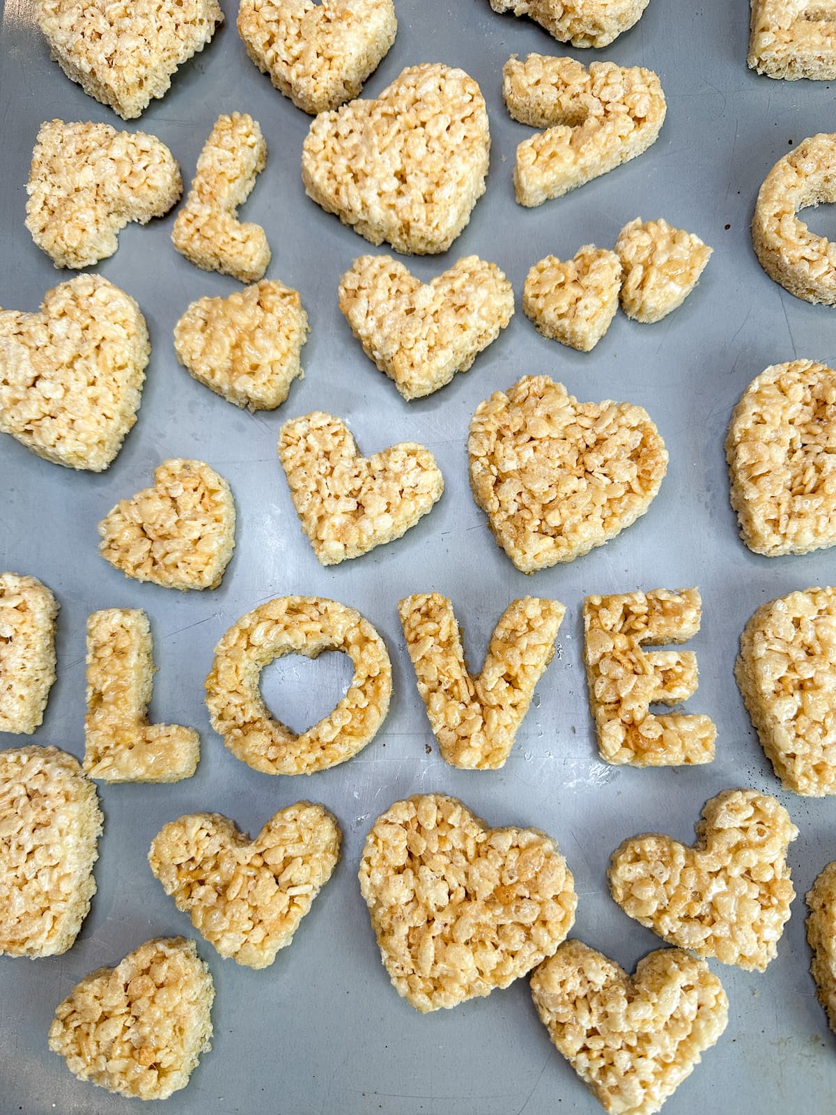 Making festive Rice Krispie Valentine’s Day treats cut out with cookie cutters