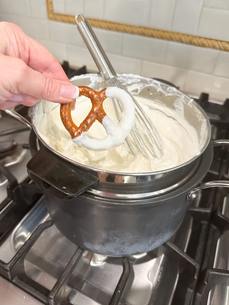 Dipping pretzels in melted white chocolate