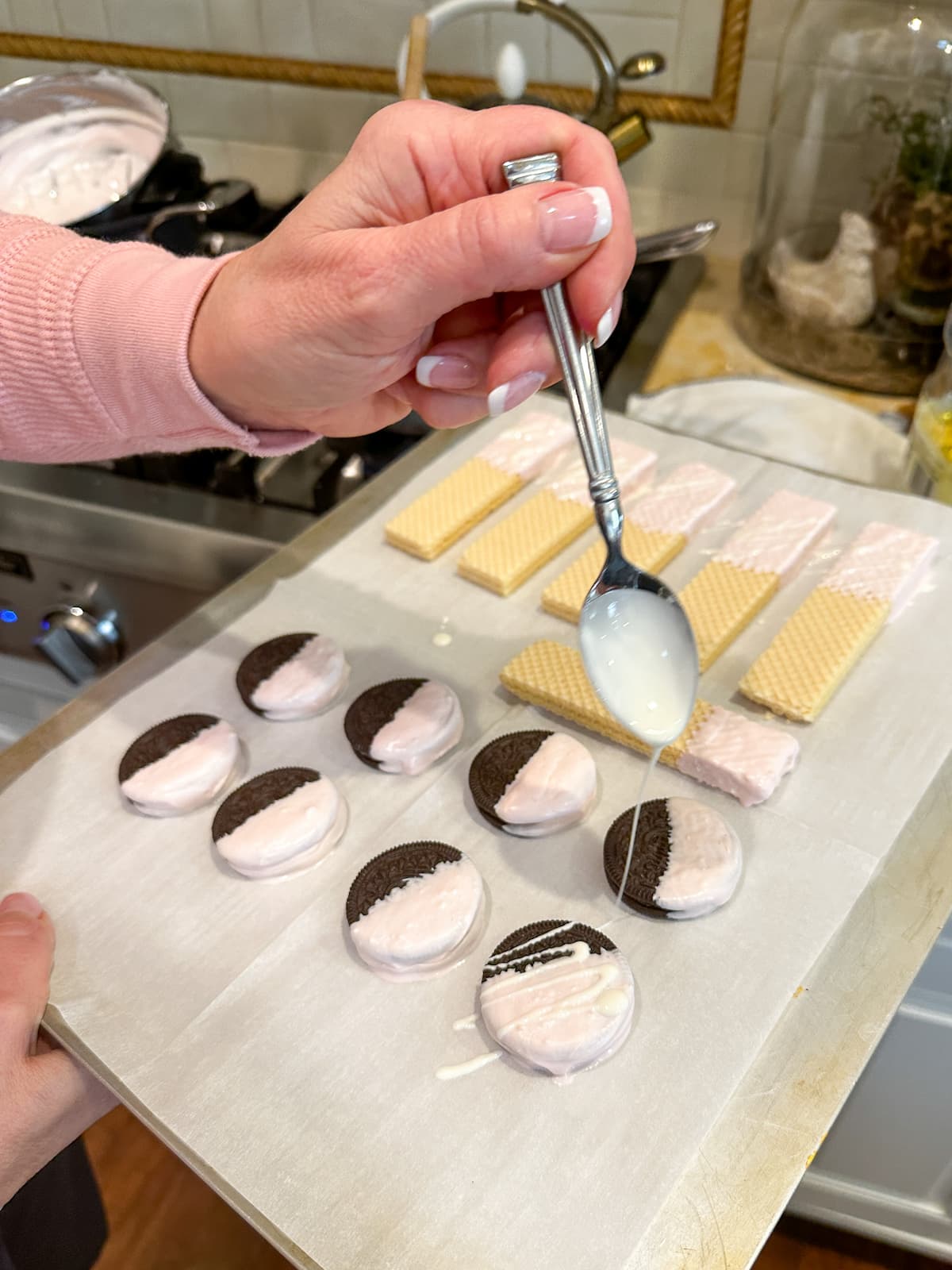 drizzling chocolate on Oreos and Vanilla Wafers for Valentine's Day