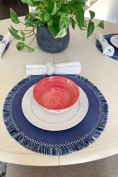 blue placemat with red and white dishes 