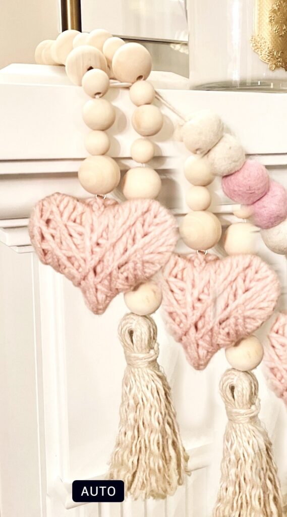 Pink yarn hearts wrapped with wood and felt beads. 
