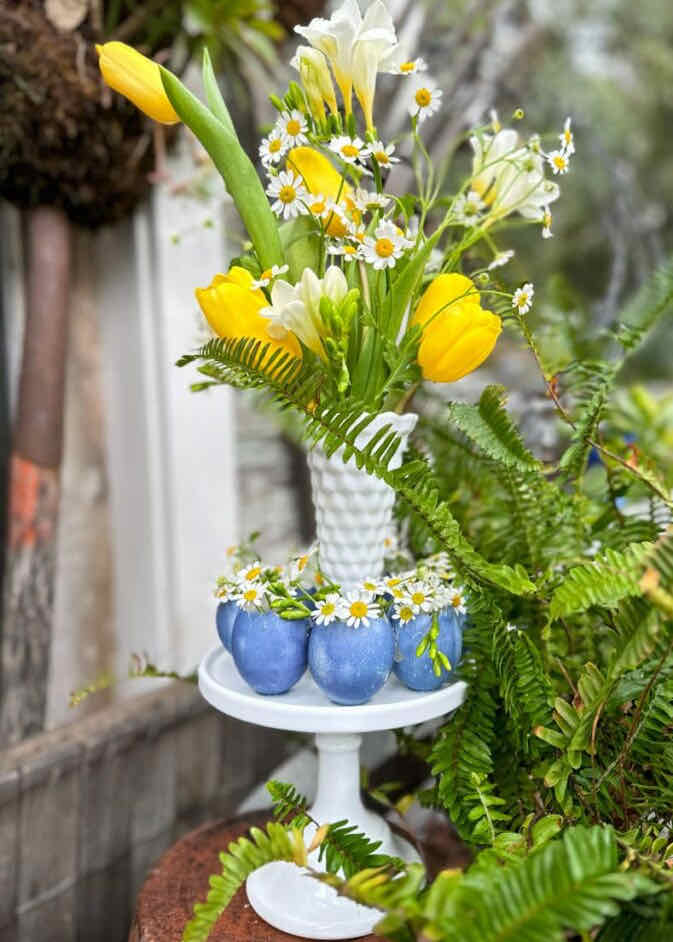 21 flowers- Yellow tulips in a white vase surrounded by an eggshell wreath with flowers 