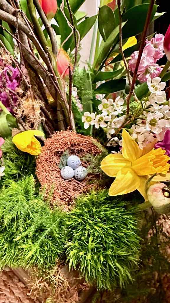 Birds nest sitting in a flower arrangement 
