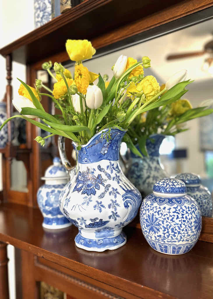 spring mantel ideas-Yellow and white flowers in blue and white vase on fireplace mantel