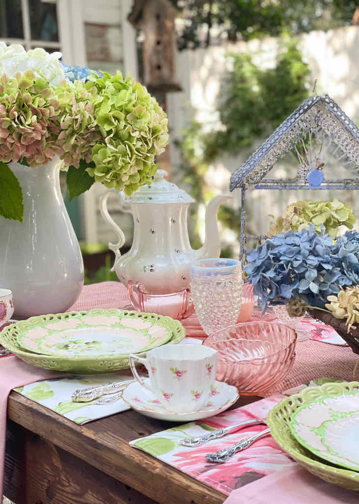 - hydrangeas on a tablescape outside with a pink tablecloth 