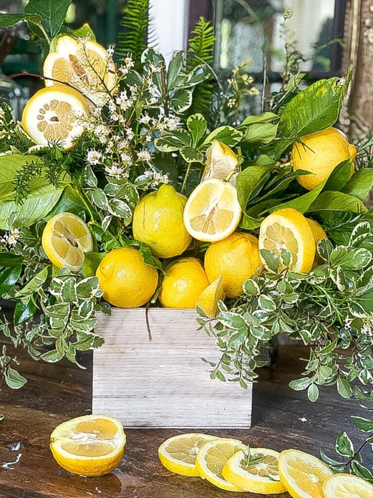 29 things to do with your extra lemons-a floral arrangement in a wood box made using whole and sliced fresh lemons 