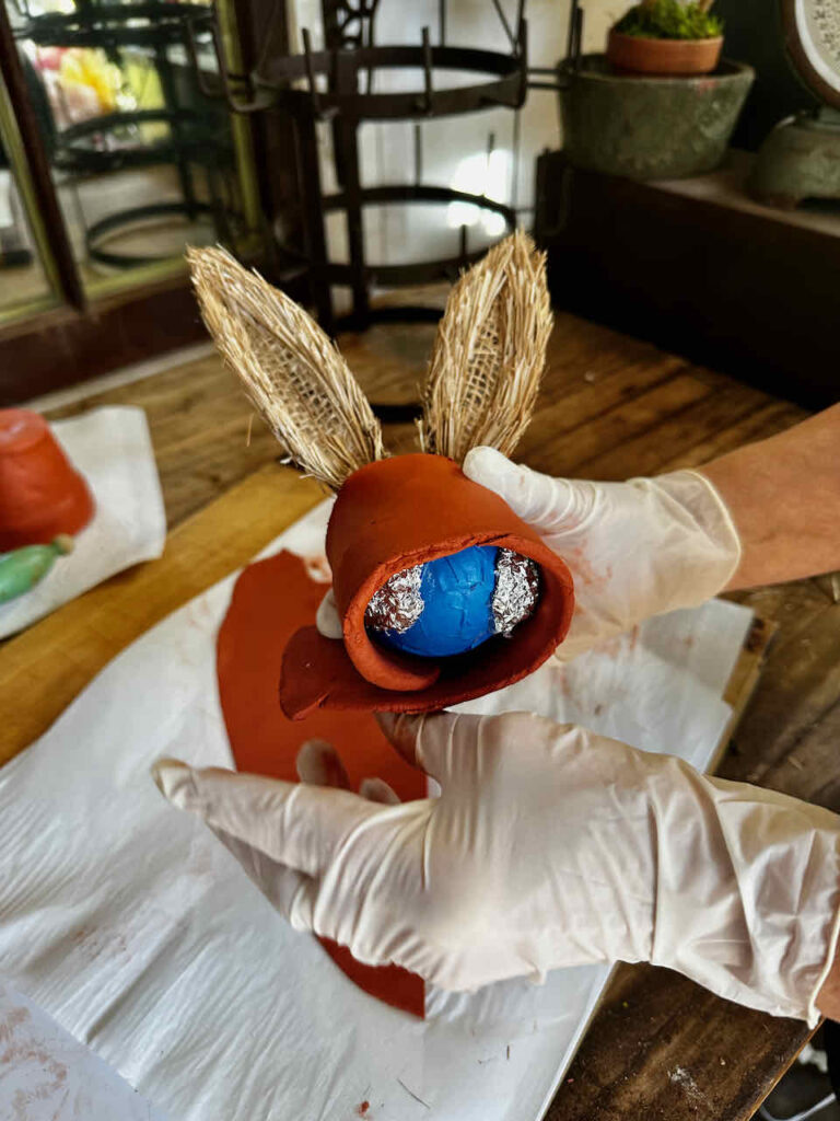 DIY Easter Rabbit- Easter egg and clay used to create a rabbit head. Foil used to create cheeks and added raffia rabbit ears.