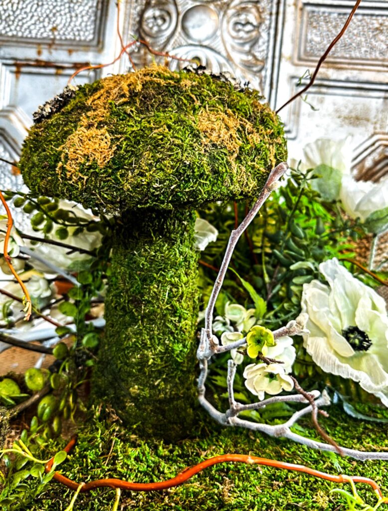 DIY SPRING MOSS MUSHROOM moss mushroom sitting in a table as decoration with some white twigs and white flowers