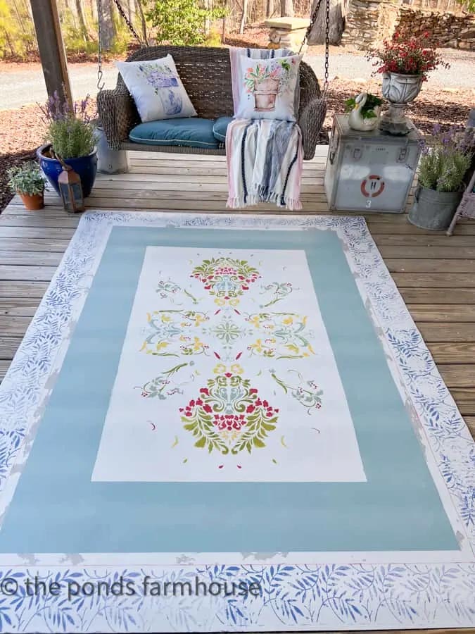 DIY rug that is hand stenciled sitting on a front porch 