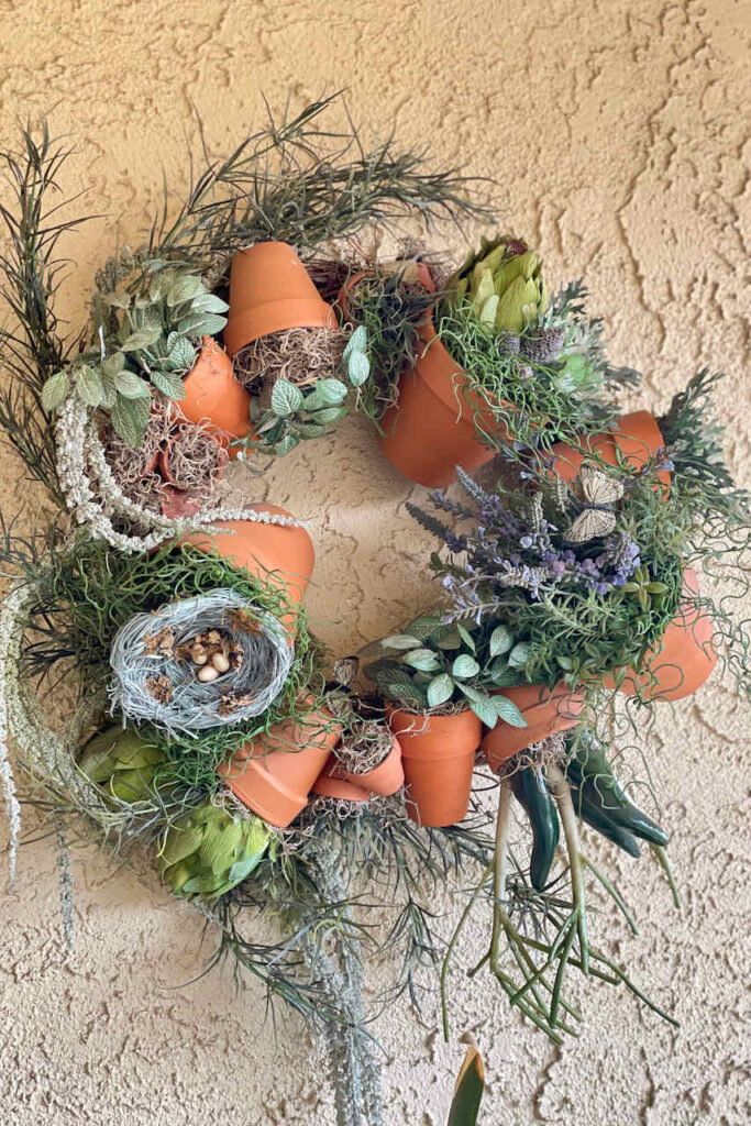  A wreath made of clay pots, decorated with moss and faux greeenery
