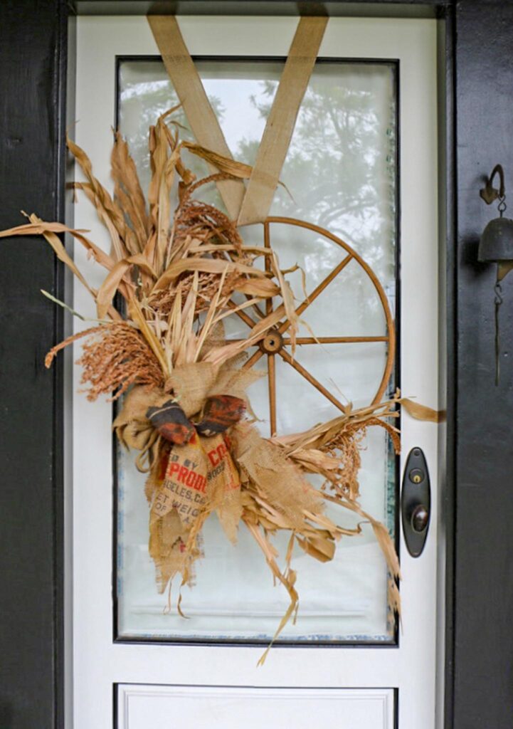 fall wagon wheel wreath with corn husks and burlap bow 
