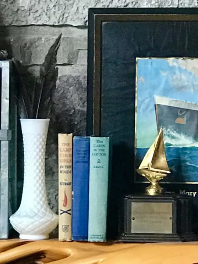 A vignette of vintage finds, a picture, trophy, books and flower vase